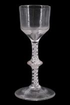 A mid 18th Century opaque twist wine glass, having an ogee bowl and blade-knopped stem with ribbon