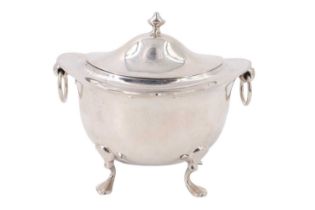 An Edwardian silver tea caddy, of oblate section having an everted rim raised on four feet with a