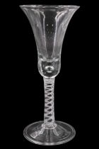 A reproduction George III large opaque twist-stem wine glass, having a bell-shaped bowl with tear to