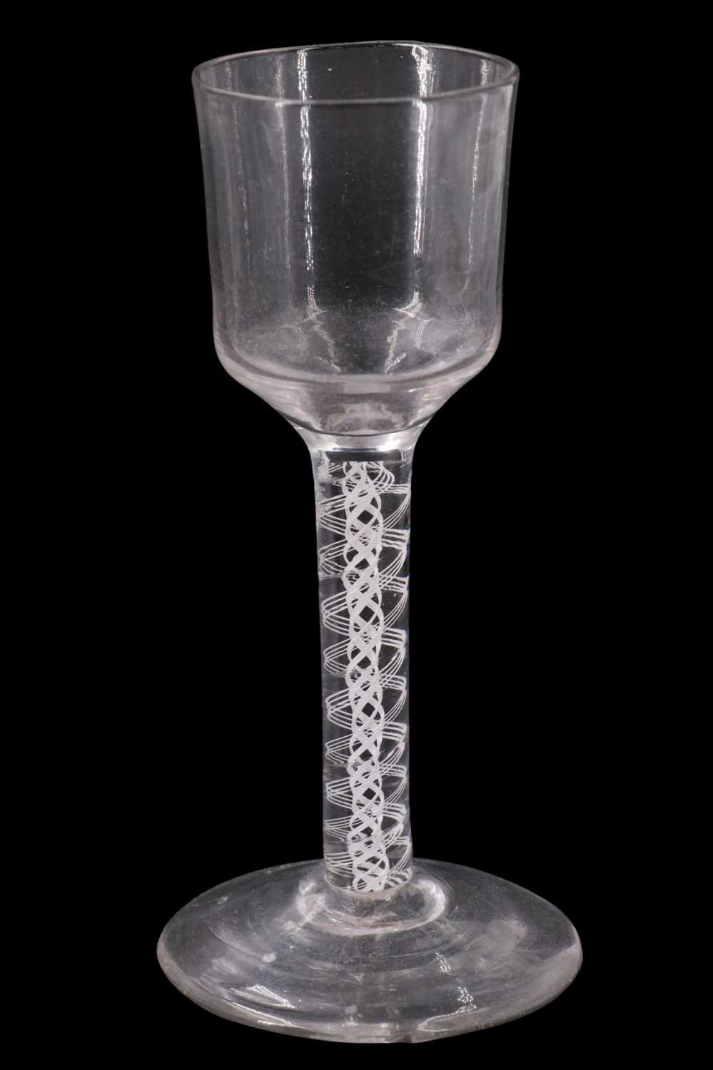 A mid 18th Century opaque twist stemmed wine glass, having a near square bucket bowl and compound