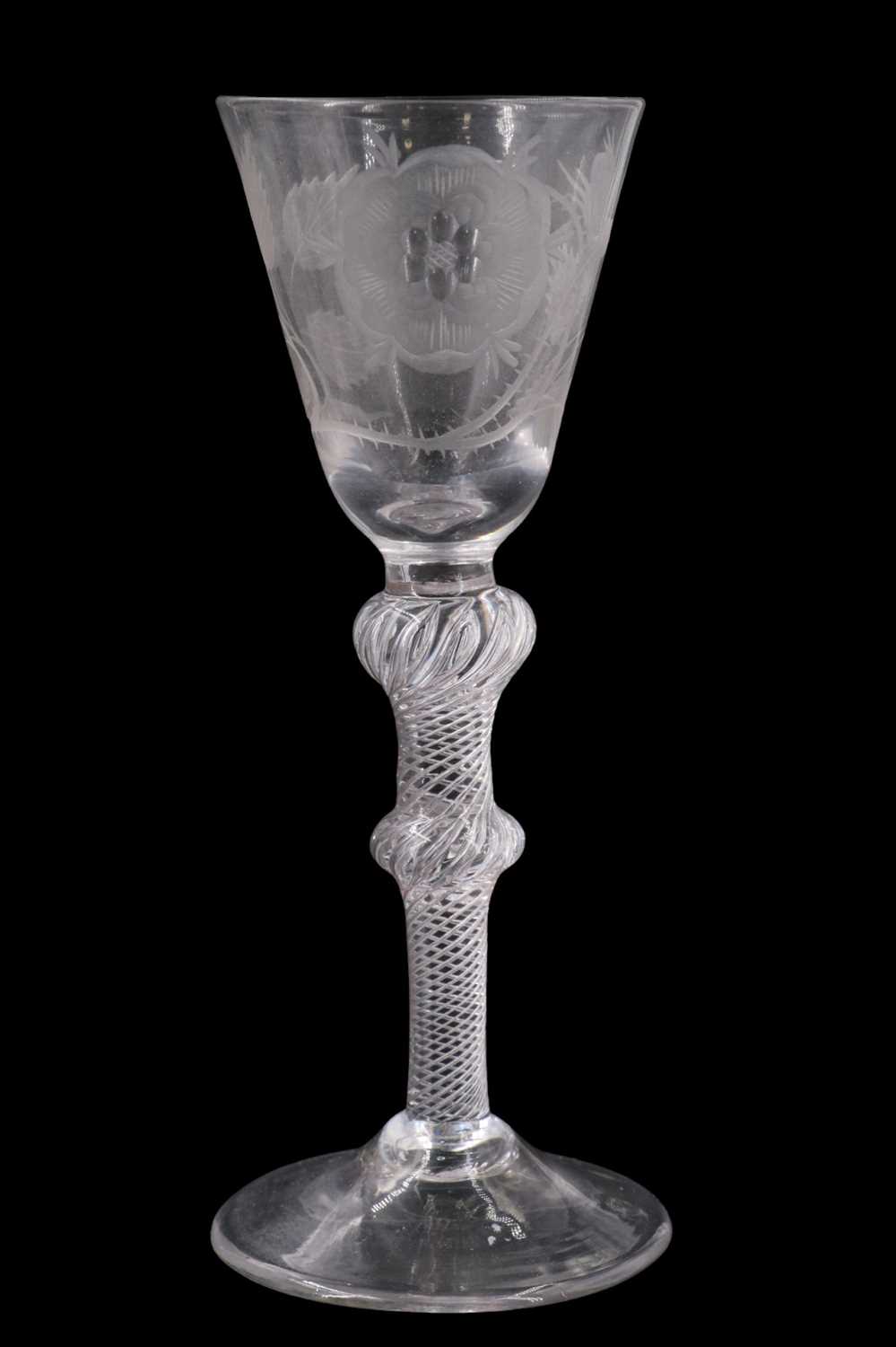 A Jacobite wine glass, having a conical funnel bowl and double-knopped multiple spiral air twist