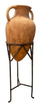 An earthenware terracotta amphora on wrought iron stand, 89 cm tall