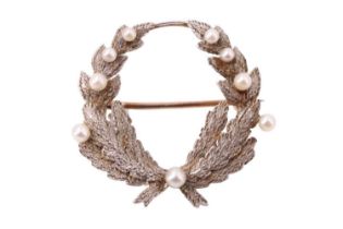 A pearl set laurel-wreath brooch, the white metal leaves set with nine various seed pearls on a