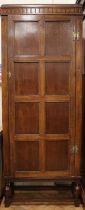 A 1930s carved oak hall cupboard, internally fitted with adjustable shelves, 82 x 33 x 202 cm