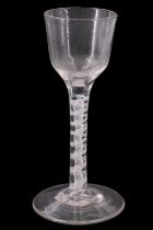 A mid 18th Century opaque twist wine glass, having an ogee bowl and thread ribbon and subtly