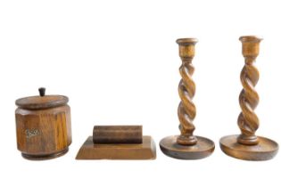 A pair of oak bine twist candlesticks together with an oak tea caddy and walnut paperweight, 1920s -