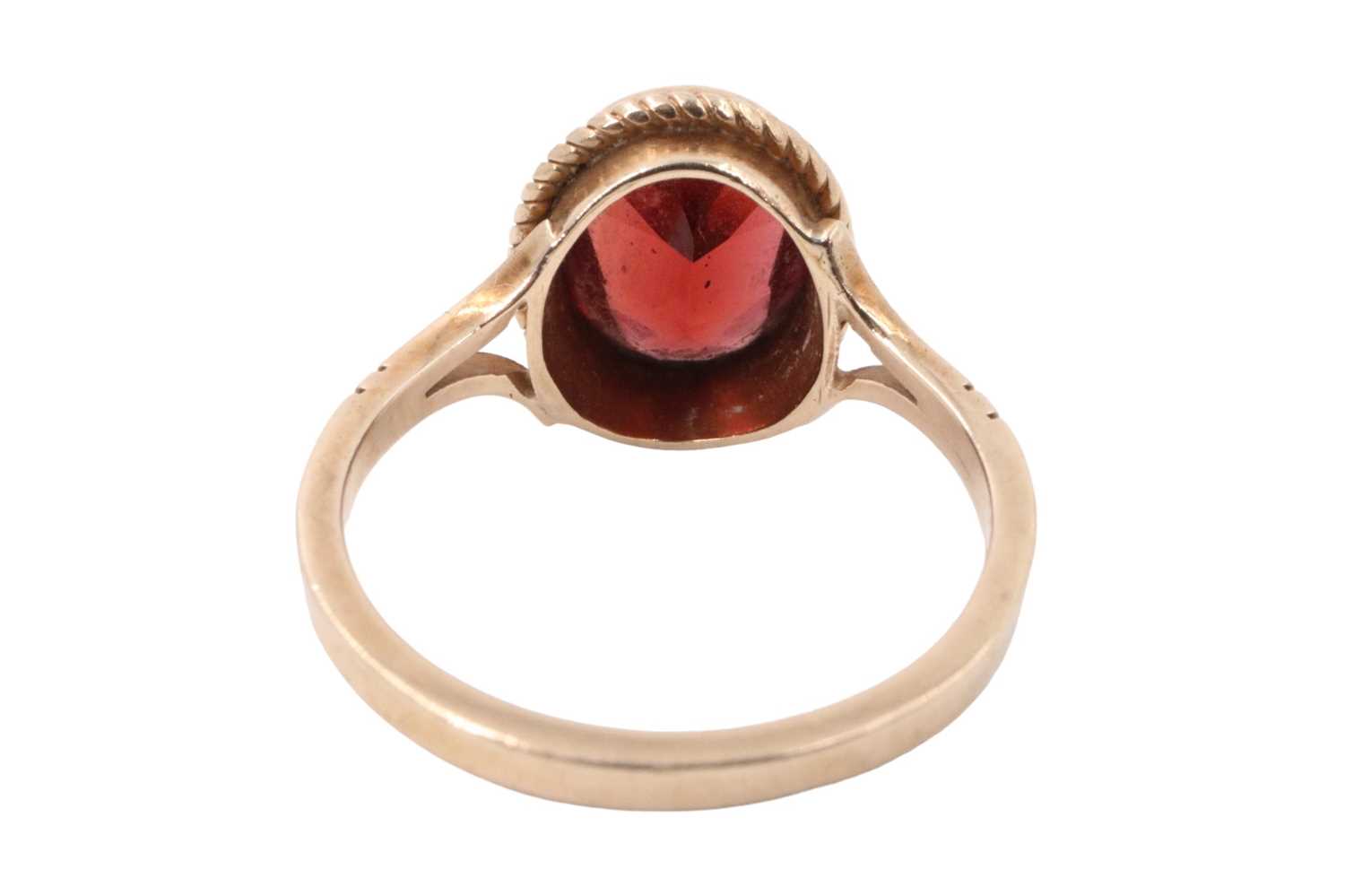 A garnet dress ring, the facet-cut oval stone (approx 9 mm x 7 mm) bezel-set within a pair of cables - Image 4 of 5