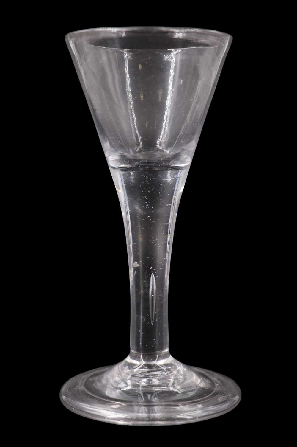 A mid-18th Century drawn trumpet wine glass, having a teared stem and folded foot, 14.5 cm, (free of