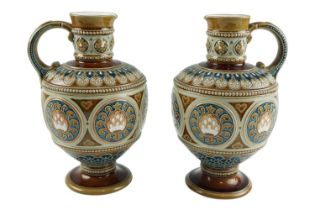 A pair of late 19th Century Mettlach stoneware ewers, of shouldered ovoid form on pedestal bases and