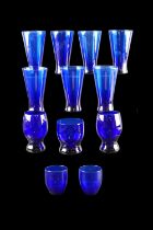 A set of cobalt blue glass conical beakers together with other similar drinking glasses, tallest