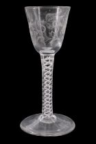 An old reproduction George III opaque twist stemmed wine glass, its ogee bowl decorated with wheel-