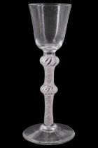 A George III opaque twist wine glass, having a round funnel bowl and double-inverted-baluster stem