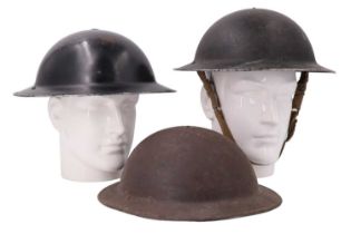 Two Second World War Civil Defence steel helmets together with an Army Mk II helmet
