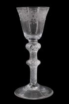 A George III air twist and wheel cut wine glass, having a conical funnel bowl decorated with