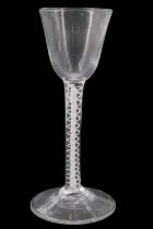 A mid 18th Century opaque twist wine glass, having a conical funnel bowl and multiple spiral