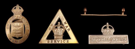 An Imperial Service Badge, two Great War "On War Service" lapel badges and a wounded stripe