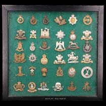 A framed display of cavalry cap badges