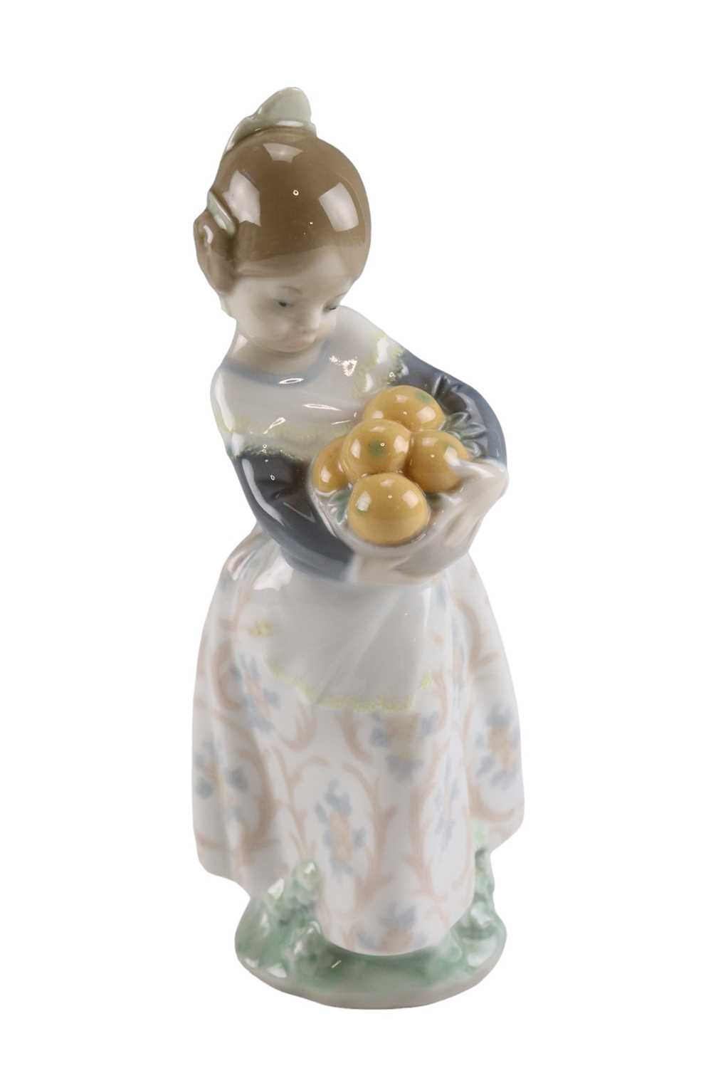 A Lladro figurine of a young girl holding a basket of fruit, height 17.5 cm