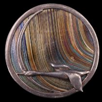 A contemporary Scottish circular silver and iridescent glass brooch by Pat Cheney, being an openwork