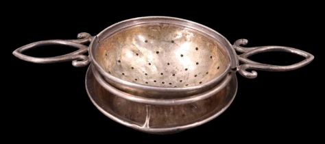 A George V silver tea strainer and stand, having open lug handles, Birmingham, 1918, 12 cm, 35 g, (