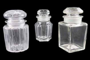 Three Victorian and later cut glass toiletry jars having ground-in stoppers, height 15 cm