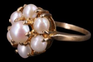 A 1970s daisy set pearl ring, having a 5 mm pearl set above a surrounding annulus of six 4 mm