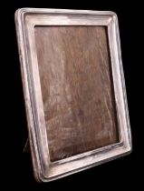 An early 20th century silver-faced oblong photograph frame ornamented with a raised linear cusp