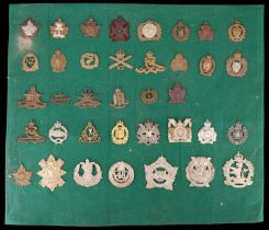 A collection of Canadian and Dominions cap badges affixed to a board