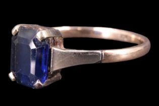 A vintage sapphire finger ring, comprising an emerald cut blue sapphire of approximately one carat