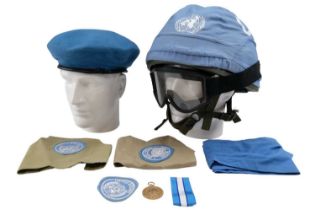 A British military Mk 6 helmet with goggles and UN cover, a United Nations medal, a beret, cravat