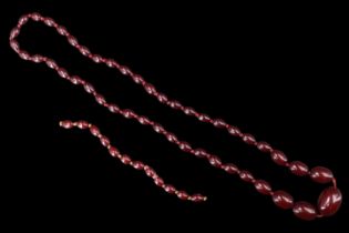 A cherry Bakelite bead necklace, comprising an opera length string of graduated beads, the largest