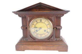 An early 20th Century German oak mantle clock by Junghans, striking on a gong in an architectural