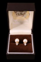 A pair of pearl and diamond earrings, each comprising a pearl of approx 7 mm, cradle set below a