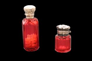 Two Victorian silver-mounted ruby glass smelling salts / scent bottles, each having a ground-in