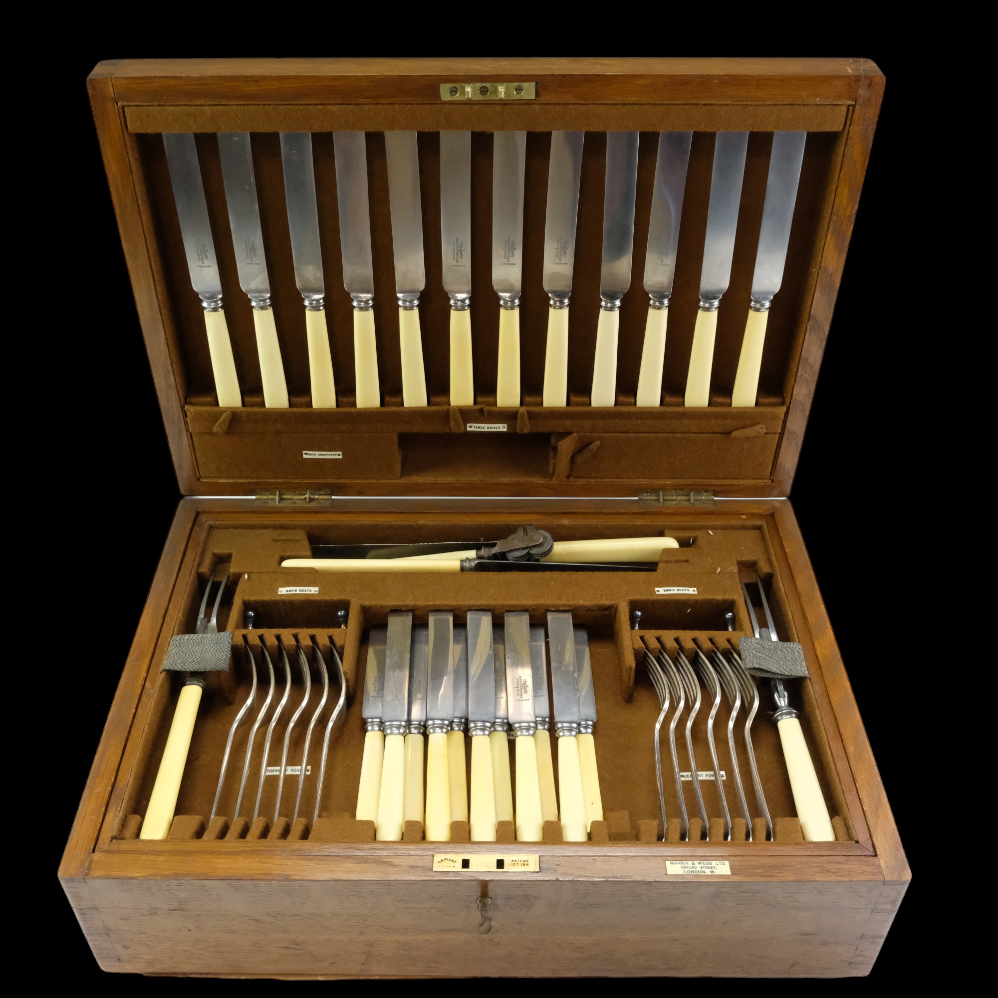 A Mappin & Webb brass-mounted oak canteen containing a suite of Ivorine and electroplate cutlery and