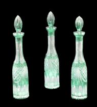 Three emerald flashed and cut glass wine decanters, circa 1970s, tallest 43 cm, ("flea bites" to two