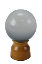A fortune teller's "crystal" ball on a turned wooden stand with black velvet cover, 14 cm overall