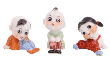 Three miniature Japanese porcelain figurines of seated children, numbered to bases, circa 1920s,