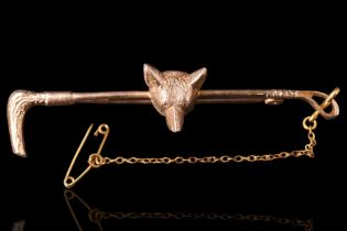 A 9 ct gold fox's mask and riding crop bar brooch or stock pin, 6 cm, 6.4 g