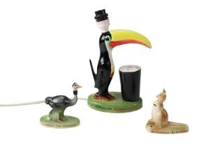 A reproduction Guinness toucan ceramic table lamp together with two reproduction figurines, lamp