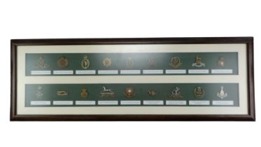 A framed display of British army cap badges