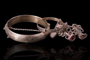 A 1960s silver bangle together with a 1970s silver charm bracelet and a white-metal Christening