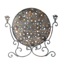 A Chinese bronze patinated fire screen, the central element comprising a disc of cash coins, 65 cm x