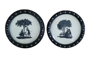 A pair of early 20th Century silhouettes depicting two lovers beneath a tree, in Regency-style