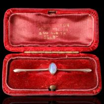 A late 19th / early 20th Century opal and yellow metal bar brooch, the oval opal cabochon of