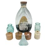 A group of stoneware and glass ink bottles together with a large Swan Inks ink bottle and partial