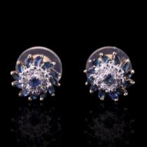 A pair of sapphire and diamond spiral cluster earrings comprising a central cluster of small diamond