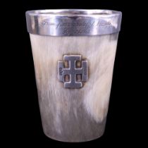 An early 20th Century silver-mounted horn beaker, faced with a Jerusalem cross and having a collar