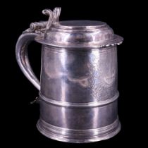 A William III silver lidded tankard, of typical subtly tapered form, its flat-topped lid having a