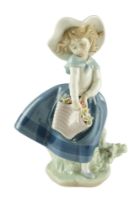 A Lladro figurine of a young girl holding a basket of flowers, late 20th Century, height 18 cm